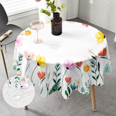 a white table with flowers on it next to two chairs and a vase filled with flowers