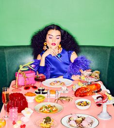 a woman sitting at a table covered in food