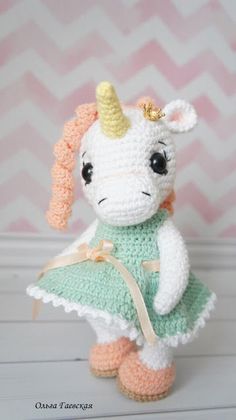 a crocheted stuffed animal wearing a green dress