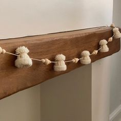 a wooden mantle with white pom - poms hanging from it's sides