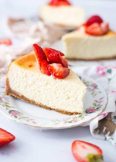 a slice of cheesecake with strawberries on top is sitting on a floral plate