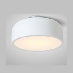 a white ceiling light that is on top of a gray wall and has a circular light fixture