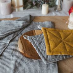 a wooden plate topped with an orange and yellow cloth next to some other items on a table