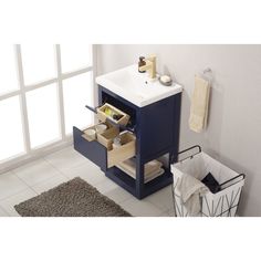 a white sink sitting next to a blue cabinet in a bathroom on top of a tiled floor