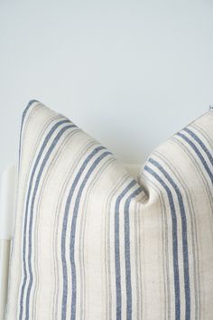 a white and blue striped pillow sitting on top of a bed