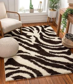 a zebra print rug in the corner of a room with a chair and potted plant