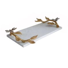 two brass leaves on a white marble tray