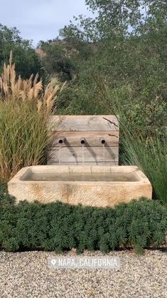 an outdoor fountain surrounded by plants and rocks