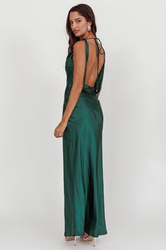 a woman wearing a green dress with open back and high slits on the side