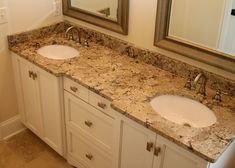 two white sinks sitting next to each other on top of a marble countertop in a bathroom