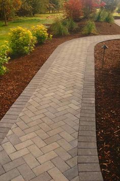 a brick walkway in the middle of a garden