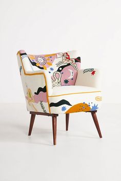 an upholstered chair with colorful designs on the armrests and back rests against a white background