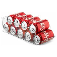 six cans of coca - cola are stacked in a clear holder on a white background