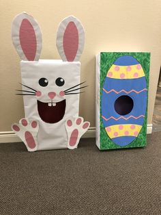 two cardboard easter baskets sitting next to each other on the floor in front of a wall