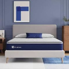 an image of a blue and white mattress in a room with two nightstands on either side