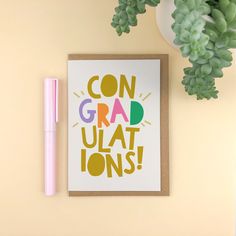 a card with the words congratulations on it next to a pen and succulent plant