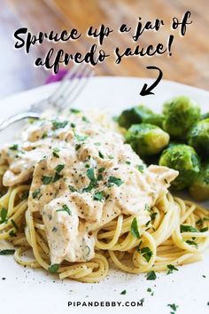 a white plate topped with pasta covered in sauce next to brussel sprouts