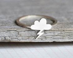 This lightning cloud ring is made to order to fit your personal size. Height of the lightning cloud: 1cm Material: solid sterling silver Finish: matt Matching lightning cloud necklace: https://www.etsy.com/listing/89023239 Other materials and sizes are also available upon request. More rings with no gemstone: https://www.etsy.com/uk/shop/huiyitan?section_id=7532330 More designer jewelry: huiyitan.etsy.com For our behind the scenes: https://www.youtube.com/user/sthyt Lightning Ring, Lightning Cloud, Cloud Ring, Celestial Jewelry, Weather Forecast, Lightning Bolt, Amethyst Ring, Fine Silver, Silver Band