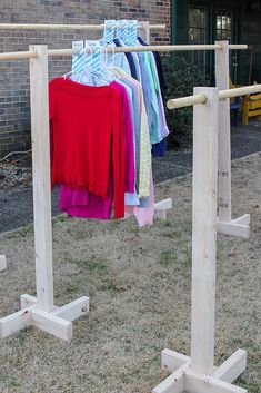 clothes are hanging on wooden racks outside in the grass