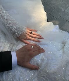 the bride and groom are holding hands on their wedding dress, which is covered in sequins