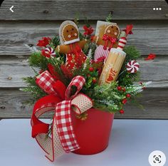 a red bucket filled with christmas treats and decorations