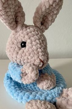 a crocheted stuffed animal sitting on top of a white table next to a wall