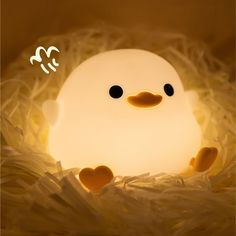 a small light that looks like a bird in the nest with hearts on it's feet