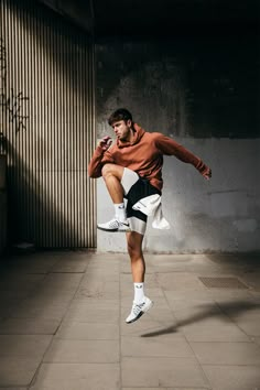 a man is jumping in the air with his feet up and one hand on his hip