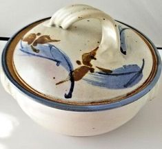 a white bowl with blue and brown designs on it