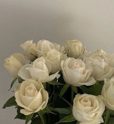 a vase filled with white roses on top of a table