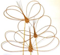 two metal sculptures made to look like flowers with long stems in the shape of petals