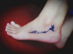 a small tattoo on the foot of a person with an airplane and name written in cursive writing