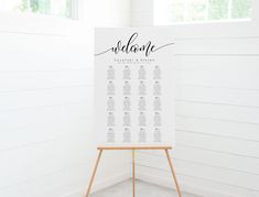 the seating chart is displayed on an easel in front of a white painted wall