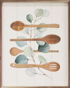 wooden spoons and spatulas are arranged in a wood frame on a white wall