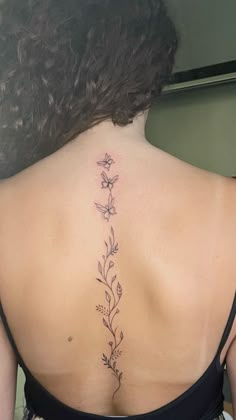 the back of a woman's neck with flowers on it