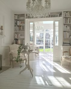 a living room filled with furniture and a chandelier