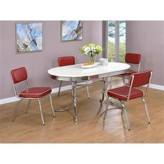 a white table with four red chairs in front of purple walls and hardwood flooring