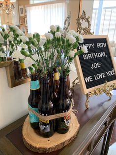 there is a sign that says happy 50th and some bottles with flowers in them on the table