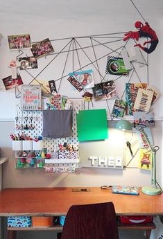 a wooden desk topped with a laptop computer next to a wall covered in pictures and magnets