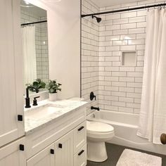 a white bathroom with black and white accessories