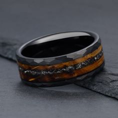 a wooden ring with black and brown wood inlays on it's side