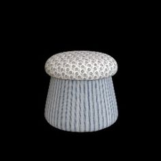 a blue and white striped stool on a black background with the lid up to show it's fabric