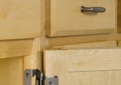 a close up view of the handles on a cabinet door with wood grain and metal hardware