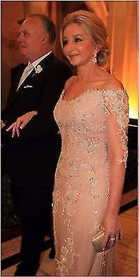 a woman in a long dress standing next to a man wearing a tuxedo