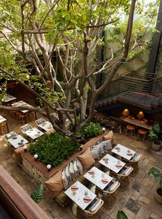 an outdoor dining area with tables, chairs and potted plants on the side wall