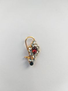 a pair of earrings sitting on top of a white table next to a black and red object