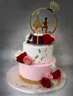 a three tiered cake with red roses on the bottom and gold trimmings