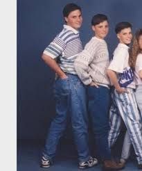 a group of young people standing next to each other in front of a blue background