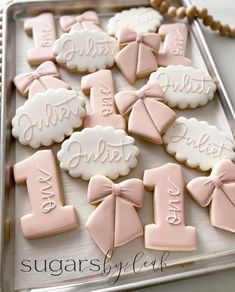 cookies decorated with pink and white icing are on a cookie sheet that says congratulations