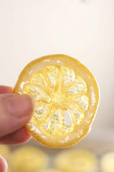 a hand holding an orange slice with the words how to make easy candied lemons